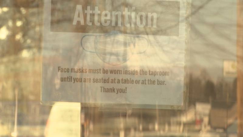 A sign is placed on the front door of Zambaldi Beer in Green Bay telling people to wear masks.