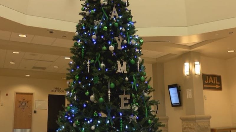 Barron County Justice Center Christmas tree is accented with green lights and green ribbons,...