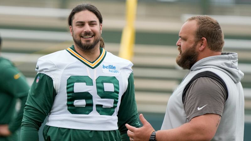 Green Bay Packers' David Bakhtiari talks to coach Luke Butkus during an NFL football OTA...