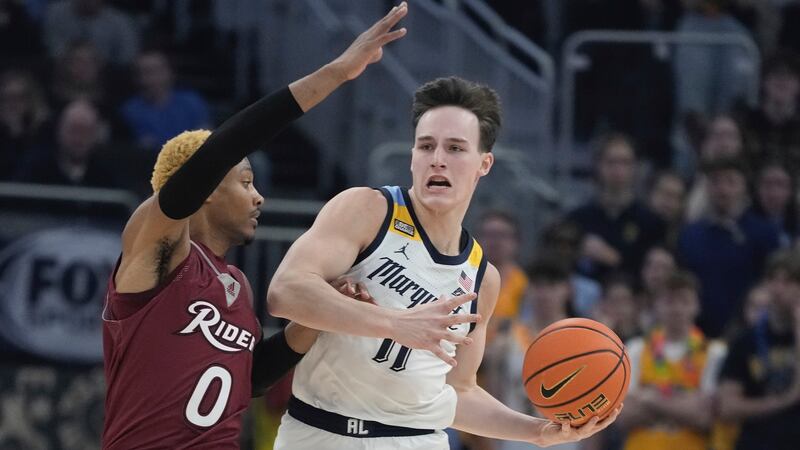 Marquette's Tyler Kolek gets past Rider's DJ Dudley during the first half of an NCAA college...