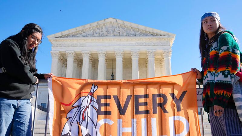 FILE - Demonstrators stand outside of the U.S. Supreme Court, as the court hears arguments...