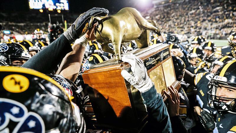 Players for the Iowa Hawkeyes hoist the Heartland Trophy in Kinnick Stadium on Saturday, Nov....