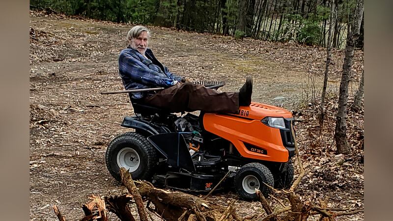 FILE -- Geoffrey Holt rests his leg on top of his riding mower in Hinsdale, N.H., on April 4,...