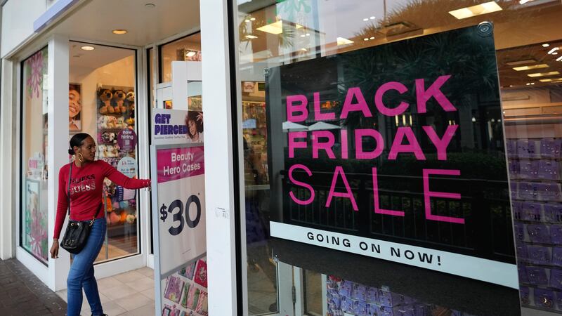 Shoppers exit a Claire's accessories store advertising sales ahead of Black Friday and the...