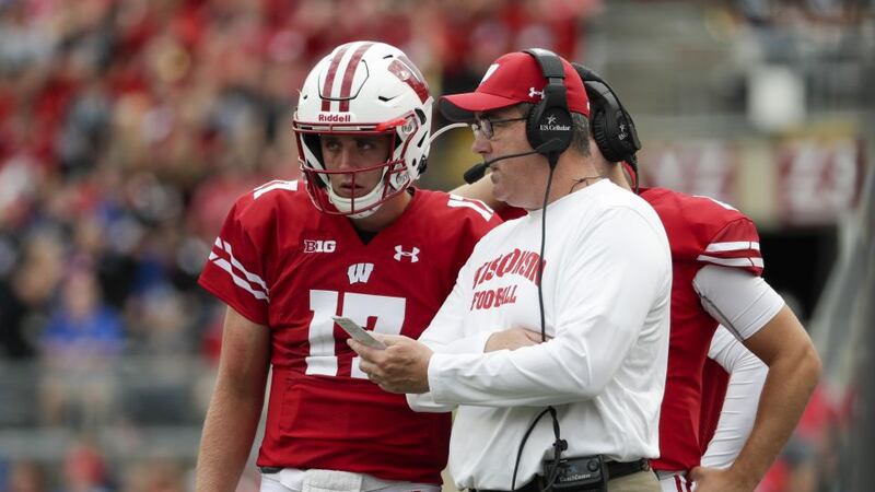 Wisconsin head coach Paul Chryst talks to quarterback Jack Coan during the first half of an...
